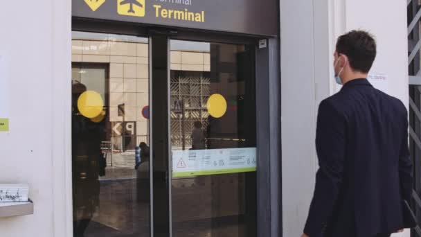 Uomo con Bagaglio su una mano Passeggiata Passato Terminal Gate e Poster Covid — Video Stock