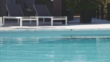 Havuz başı şutu ve havuza atlayan adam sıçrama yapıyor.