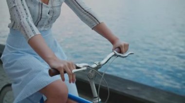 Rıhtım boyunca Bisiklete Binen Kadın