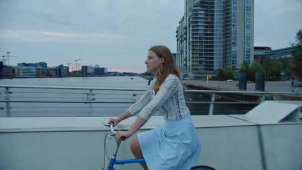 Kobieta jazda na rowerze wzdłuż mostu w mieście — Wideo stockowe