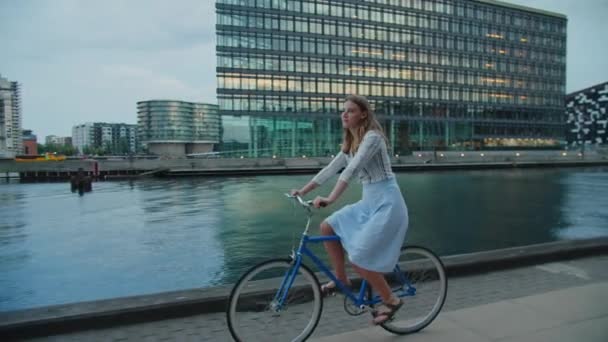 Mujer montando bicicleta azul a lo largo de la ciudad frente al mar — Vídeo de stock