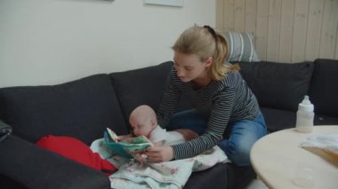 Anne, bebek için yumuşak bir oyun oynuyor.