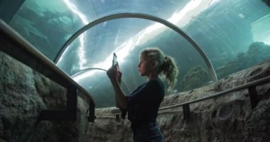 Su altı Tüneli 'nin ortasında telefonuyla fotoğraf çeken güzel kız.