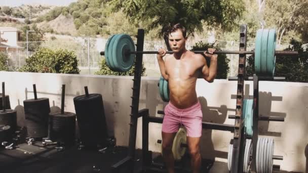 Ισχυρό αρσενικό αθλητής στην Εξωτερική Γυμναστήριο κάνει ελαστικά ανατροπές ασκήσεις — Αρχείο Βίντεο