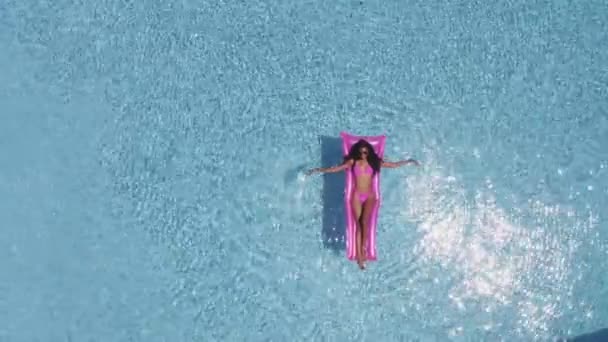 Luminoso sole che riflette sulle acque della piscina e sexy signora rilassante su Floatie — Video Stock