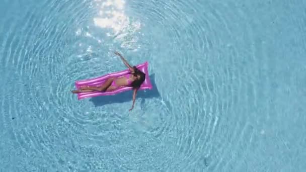 Dame in roze badpak terwijl drijvend op zwembad paardrijden een opblaasbare — Stockvideo
