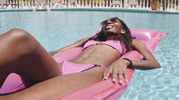 Літнє сонце і красива леді Чаклінг Перебуваючи на Флоаті біля басейну — стокове відео