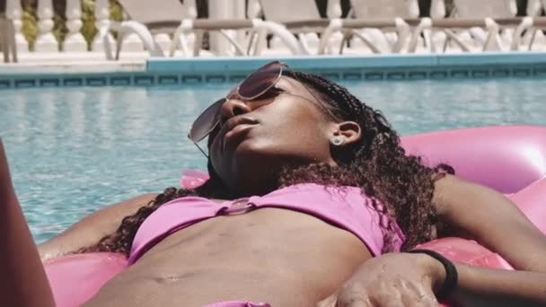 Underbar flicka flyter vid den avkopplande poolen under sommaren — Stockvideo