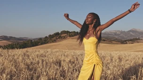 Hermosa modelo disfrutando del cálido sol mientras camina en campos abiertos — Vídeo de stock