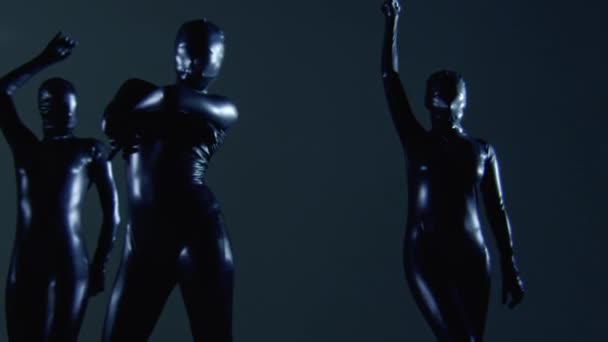 Trzy tancerki w czarnym kostiumie lateksowym jako aparat przybliża i oddala — Wideo stockowe