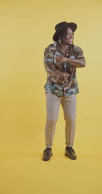 Zenci adam stüdyoda zıplıyor ve dans ediyor.