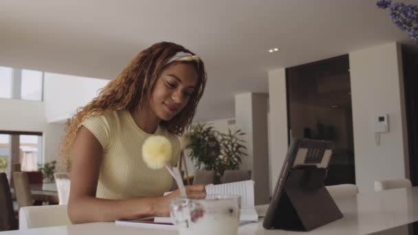 College Student Studerar i receptionen med bok och iPad framför henne — Stockvideo