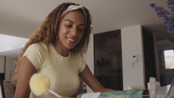 Studiøs kvinnelig student i Yellow Top Studying at Home – stockvideo
