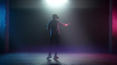 VR kulaklıklı Erkek Oyuncu Dönüyor ve Nişan Alıyor