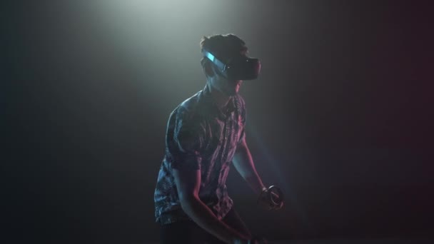 Manlig spelare i VR-headset med styrenheter — Stockvideo