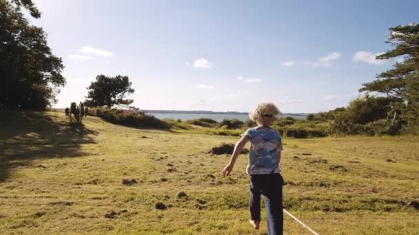 Boy Running into Meadow From Porch — Vídeo de Stock