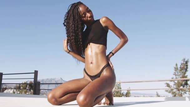 Fiatal fekete nő térdel a medencénél — Stock videók