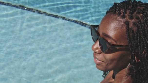 Schöne schwarze Frau sitzt am Pool — Stockvideo