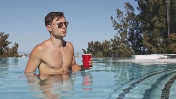 Bello giovane uomo in occhiali da sole lasciando piscina — Video Stock