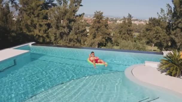 Drönare på man på uppblåsbar i poolen — Stockvideo