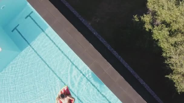 Дрон над людиною розслабляється на надувному в басейні — стокове відео