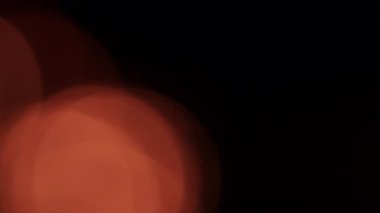 Ilık, titreyen ateş ışığı çiçek açan bokeh ile yavaşça parlar, rahat, atmosferik bir ortam yaratır.