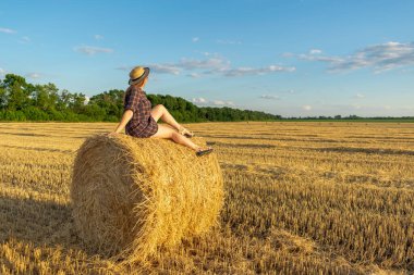 Saman tarlasında gün batımında bir kız.