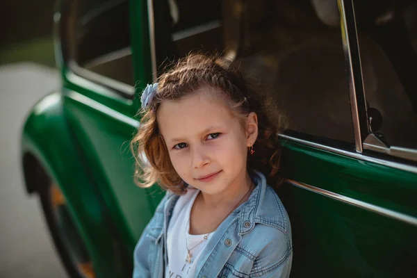 古いファッション車付近で遊んで笑顔の少女 — ストック写真