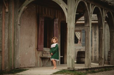 Eski bir İngiliz kale Kuzey Amerika sokaklarında yürürken stilize eski moda elbise sevimli küçük kız