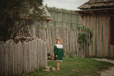 Eski bir İngiliz kale Kuzey Amerika sokaklarında yürürken stilize eski moda elbise sevimli küçük kız