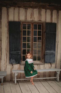 Eski bir İngiliz kale Kuzey Amerika sokaklarında yürürken stilize eski moda elbise sevimli küçük kız