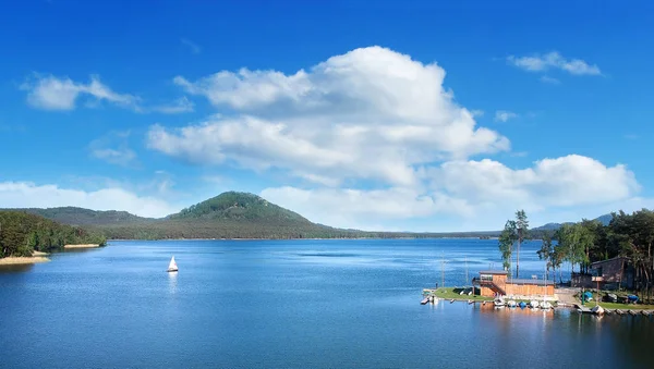 Ahşap dock ile Yatlar Mavi Göl Machovo jezero ve onu arkasında taş castle hill ve mavi gökyüzü üzerinde Bezdez olduğunu.