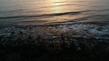 Denizdeki dalgaların havadan görünümü. Günbatımı vardır. Fuerteventura - Kanarya Adası'nda olduğunu. Güneşin turuncu sarı.