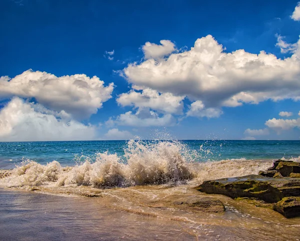 Πέτρα γκρεμό στη θάλασσα με κύμα ηλιόλουστη ημέρα το καλοκαίρι. Υπάρχει όμορφο μπλε ουρανό στο παρασκήνιο, Φουερτεβεντούρα, Κανάριοι Νήσοι, Ισπανία. — Φωτογραφία Αρχείου