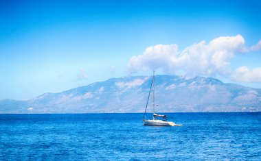 Zakynthos ada kapalı Akdeniz'in berrak suları boyunca yat yelken. Kefalonia komşu ada buradan görülebilir. İşte birkaç beyaz ile güzel bir mavi gökyüzü