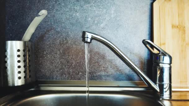 L'eau coule du robinet à l'évier dans la cuisine . — Video