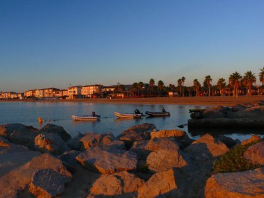 Port Grimaud yakınındaki Saint Tropez Fransa Avrupa'nın sahilde romantik gündoğumu. Denizde tekneler vardır. Gökyüzü kırmızı ve mavi deniz. Güzel manzara.