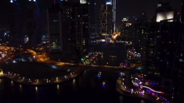 berrak deniz suyunun üzerinde ışıklı uzun evler, Dubai, UAE bir gece görünümünün 4k video.