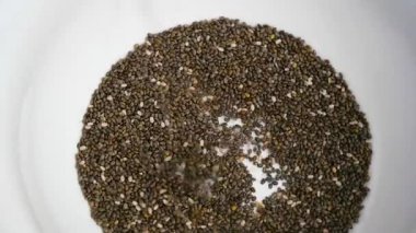 HD döndürme video Chia tohum düşmek kaşık beyaz kase.