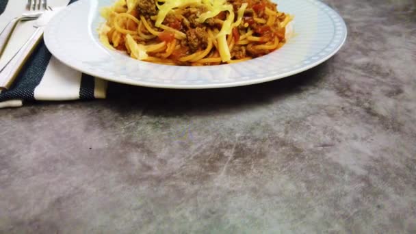 Placa de vídeo 4K con espaguetis con salsa boloñesa y queso. su sobre un fondo de mesa de madera . — Vídeo de stock