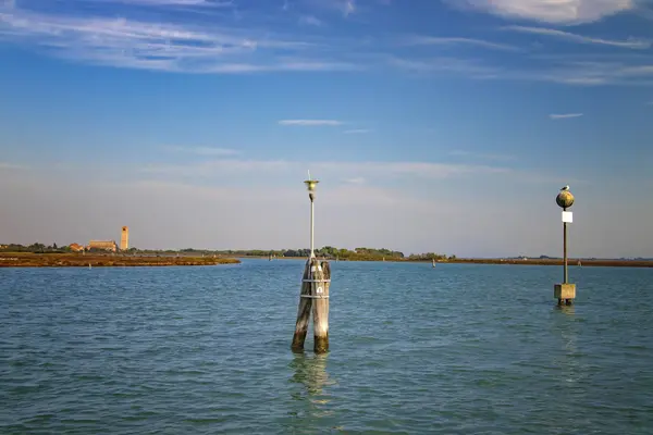 Kolom kayu di air menandai jalan kapal antara pulau Burano, Murano dan Venesia, Italia. Burung camar duduk di tiang. . — Stok Foto