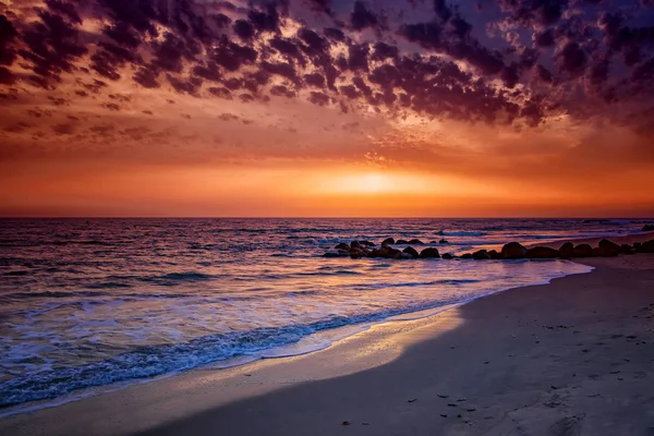Naturkulisse mit atemberaubendem Sonnenuntergang am Strand mit endlosem Horizont und unglaublichen schäumenden Wellen. Es ist Atlantik im tropischen Paradies im Senegal, Afrika. Es gibt schöne goldene Sonne. — Stockfoto