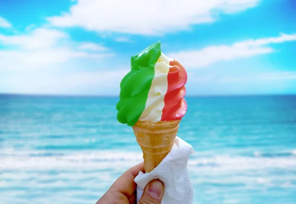 Icecream in the traditional red, white and green colours of the Italian national flag. It is tropical nature background.