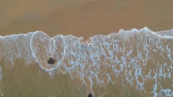 Vista aérea de la playa de arena y el océano claro. Vista superior de las olas del mar de vídeo de alta definición, volando sobre la playa de arena tropical y las olas, hay salida del sol. Es un paraíso tropical . — Vídeos de Stock