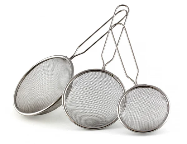 Set of kitchen strainers of different sizes on a white background. The smallest tea strainer and the largest for rice or pasta. — Stock Photo, Image
