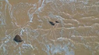 Kum plajı ve berrak okyanus havadan görünümü. Top view deniz dalgaları Hd video, tropikal kumlu plaj ve dalgalar üzerinde uçan, gün doğumu var. Tropik bir cennet..