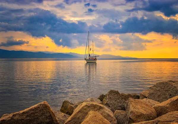 Latar belakang alami dengan Yacht di laut Mediterania saat matahari terbit, Cagliari, Italia. matahari menerangi pulau dengan warna emas yang indah — Stok Foto