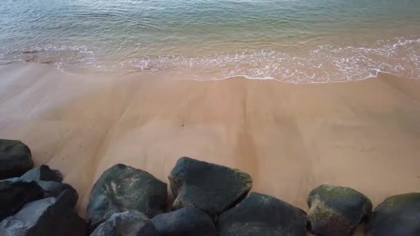 Vista aérea de la playa de arena y el océano claro. Vista superior del mar olas y piedras negras 4K video, playa de arena tropical y olas, hay amanecer en la isla de Madeira . — Vídeo de stock