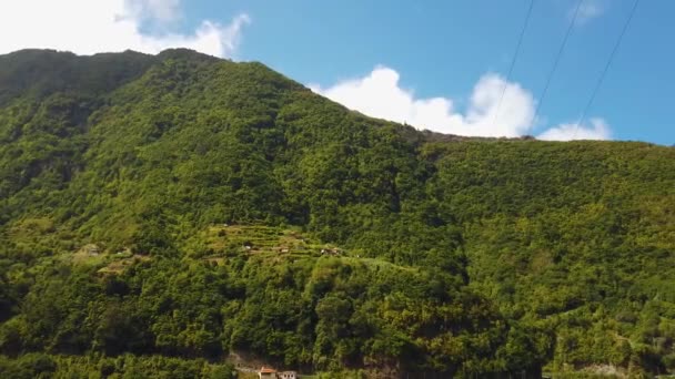 4k videó csodálatos kilátás nyílik a hegycsúcsok felett Madeira. Trópusi zöld táj, a falvak épületeit vad természetű zöld erdők veszik körül. — Stock videók