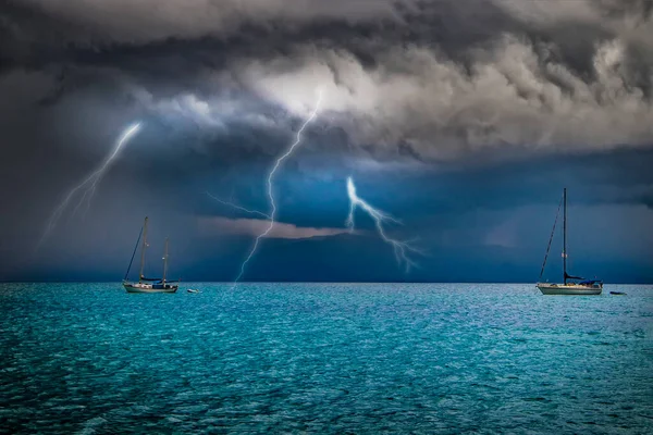 Yacht berada di laut dalam badai. Petir berkedip dari langit ke dalam air. Itu di Sardinia, Italia. Its hujan dari awan hitam. Stok Foto Bebas Royalti